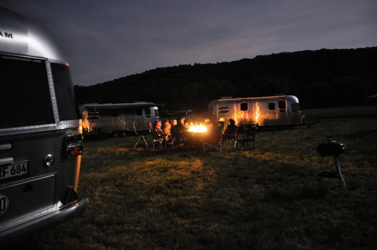 sunset and bonfire in an airstream park